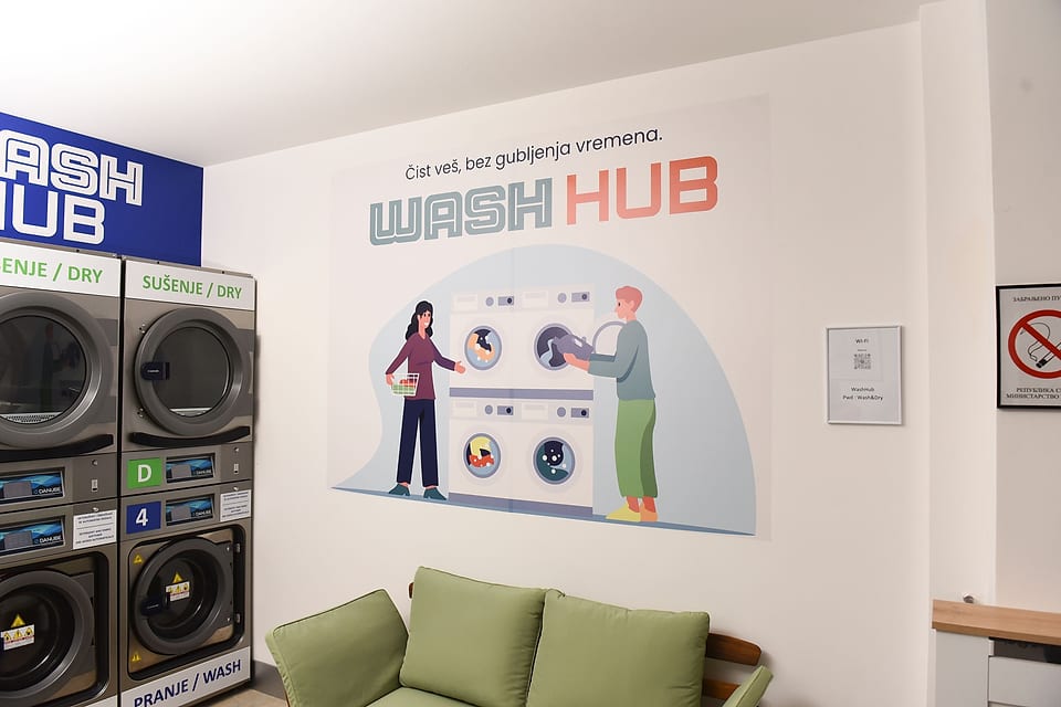Zid sa logom Wash Hub u samouslužnoj perionici veša u Beogradu